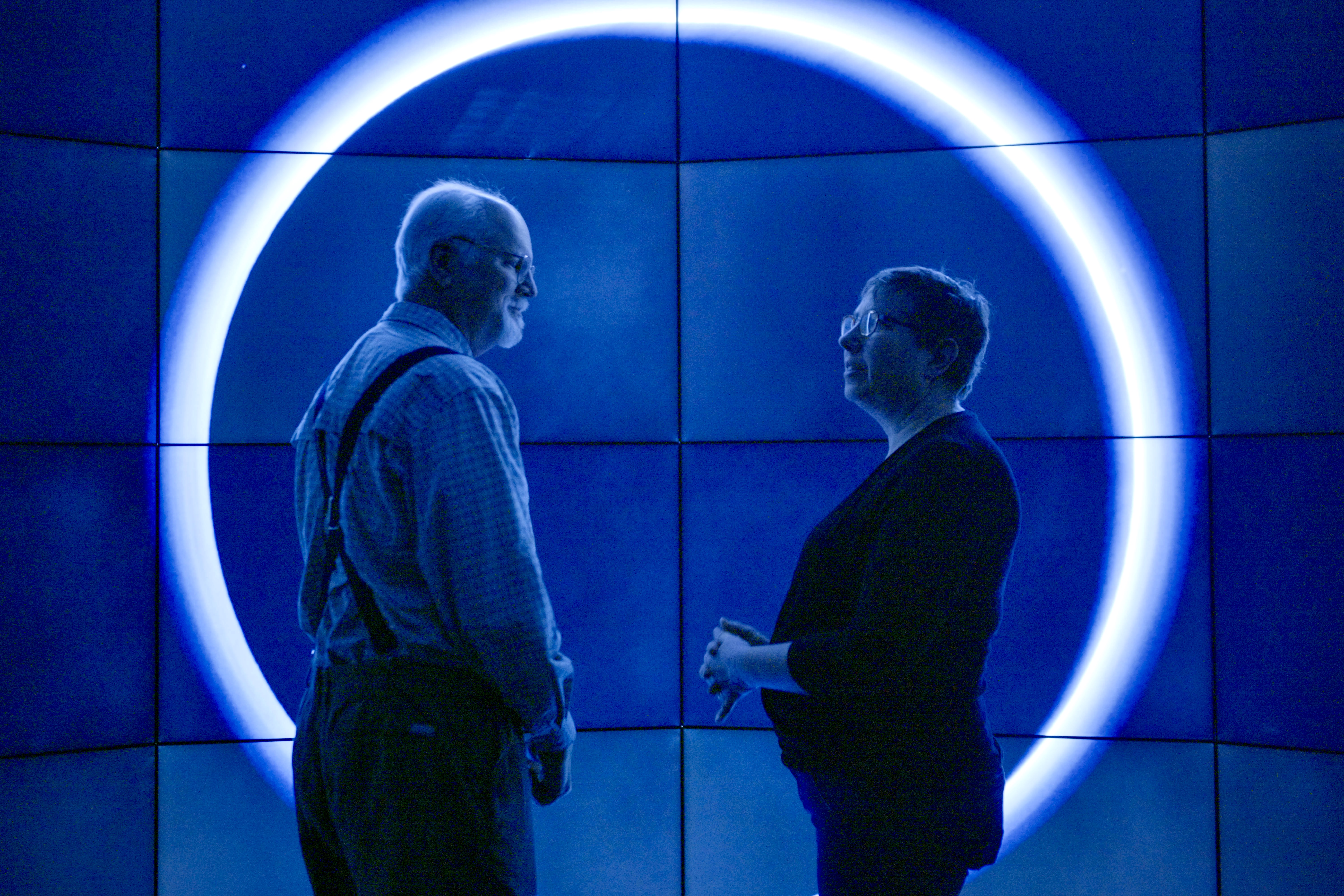 Contributors framed by a circular light installation